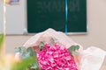A bouquet of beautiful bright flowers on a school desk on September 1st. The inscription on the school board is the Day of Knowled Royalty Free Stock Photo