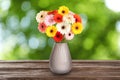 Bouquet of beautiful colorful gerbera flowers in vase on wooden table outdoors. Bokeh effect Royalty Free Stock Photo