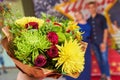 A bouquet of beautiful flowers, a couple of young people in the background out of focus Royalty Free Stock Photo