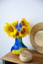 Bouquet of beautiful flowers, wicker box and hat on wooden table indoors Royalty Free Stock Photo