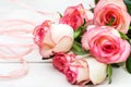 Bouquet of beautiful fresh pink roses with ribbon on white wooden table. Holiday background Royalty Free Stock Photo