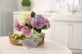 Bouquet of hydrangea flowers and apples on table in kitchen, space for text. Interior design