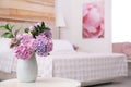 Bouquet of beautiful hydrangea flowers on table in bedroom, space for text. Interior design