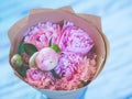 A bouquet of beautiful pink peonies on a bluish wooden table against soft-focused background. Royalty Free Stock Photo