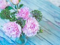 A bouquet of beautiful pink peonies on a bluish wooden table against soft-focused background. Royalty Free Stock Photo