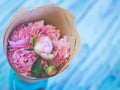 A bouquet of beautiful pink peonies on a bluish wooden table against soft-focused background. Royalty Free Stock Photo