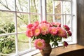 Bouquet of beautiful pink peonies near a large window. Royalty Free Stock Photo