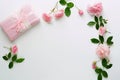 Bouquet of beautiful pink roses and gift in pink packing on white background.Top view.Copy space Royalty Free Stock Photo