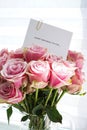 Bouquet of beautiful pink roses with a greeting card, clsoe-up. Top view