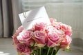 Bouquet of beautiful pink roses with a greeting card, clsoe-up. Top view