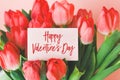 a bouquet of red tulips and a white gift card with the inscription Happy Valentine\'s Day