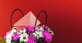 Bouquet of beautiful spring flowers in basket with love envelop, festive and holiday banner with copy space on red background