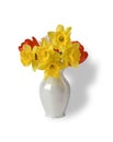 The bouquet of beautiful spring tulips and narcissuses in a vase is isolated on white