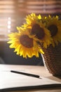 Bouquet of beautiful sunflowers, notebook and pencil  on table indoors, closeup Royalty Free Stock Photo