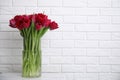 Bouquet of beautiful tulips in glass vase on white table indoors. Space for text Royalty Free Stock Photo