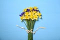 Bouquet of beautiful yellow daffodils and iris flowers on light blue wooden table, top view Royalty Free Stock Photo