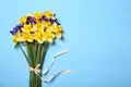 Bouquet of beautiful yellow daffodils and iris flowers on light blue wooden table, top view. Space for text Royalty Free Stock Photo