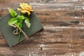 Bouquet of beautiful yellow roses and stack of old vintage books on wooden background. Copy space for nostalgic inscription Royalty Free Stock Photo