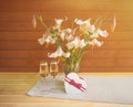 Bouquet of beige colored lilies with pink spots in glass  vase, two glasses of champagne and heart shape gift box Royalty Free Stock Photo
