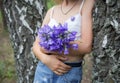 Bouquet of blooming purple Campanula flowers in the hands of a young woman