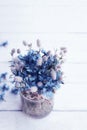 Bouquet of blue cornflowers flowers in a glass jar on an old white wooden board. Floral vintage background with wildflowers Royalty Free Stock Photo