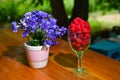 A bouquet of blue cornflowers in a vase and raspberries in a glass on the table