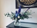 Bouquets with blue hydrangeas and white roses in glass vase on table. Royalty Free Stock Photo