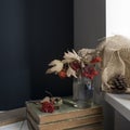 A bouquet of branches and berries of red viburnum in a transparent glass vase stands on a stack of old books. White cup of tea on Royalty Free Stock Photo