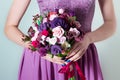 Bouquet for the bride, girl in purple evening dress holding a large bouquet of multicolored roses in hand