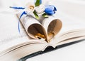 A bouquet of the bride from white and blue roses and wedding rings from gold