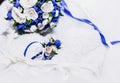 A bouquet of the bride from white and blue roses and wedding rings from gold Royalty Free Stock Photo