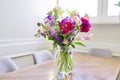 Bouquet of bright flowers on the table in jug