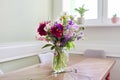 Bouquet of bright flowers on the table in jug