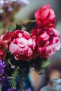 bouquet of bright rose flowers, geraniums in a blue vase on the table Royalty Free Stock Photo