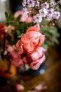 bouquet of bright rose flowers, geraniums in a blue vase on the table Royalty Free Stock Photo