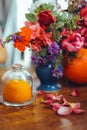 bouquet of bright rose flowers, geraniums in a blue vase on the table Royalty Free Stock Photo