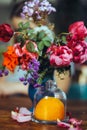 bouquet of bright rose flowers, geraniums in a blue vase on the table Royalty Free Stock Photo
