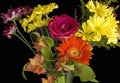 Bouquet of brilliant cut flowers in orange, pink and yellow against a black background. Royalty Free Stock Photo