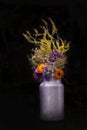 Bouquet with calendula, mallow and field grass, bunch in rustical milk churn with black background. Rustical still life.