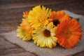 Bouquet of calendulas on canvas on wooden background Royalty Free Stock Photo