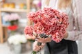 Bouquet of carnation flowers coral and red color. Spring bunch in woman hand. Present for Mothers Day.