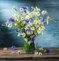 Bouquet of chamomiles and cornflowers in the vase.