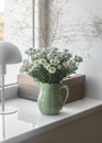 Bouquet of chrysanthemums in a vintage ceramic mug, a craft box, a lamp on the windowsill . Cozy home interior Royalty Free Stock Photo