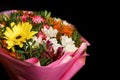 Bouquet of colorful bright flowers of chrysanthemums in a gift pink box close-up on a dark background Royalty Free Stock Photo