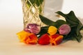 A bouquet of colorful flowers of tulips lying near a vase Royalty Free Stock Photo