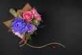 A bouquet of colorful paper flowers and a small red heart on a black background as a backdrop for a postcard, invitation letter an Royalty Free Stock Photo