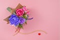 A bouquet of colorful paper flowers and a small red heart on a pink background as a backdrop for a postcard, invitation letter and Royalty Free Stock Photo