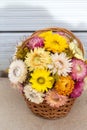 Bouquet of colourful strawflowers in a wickery basket - autum decoration of golden everlasting on the table
