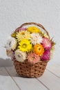 Bouquet of colourful strawflowers in a wickery basket - autum decoration of golden everlasting on the table