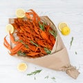 Bouquet consisting of boiled crawfish and crabs with rosemary sprigs and lemon slices on a white wooden table. View from above